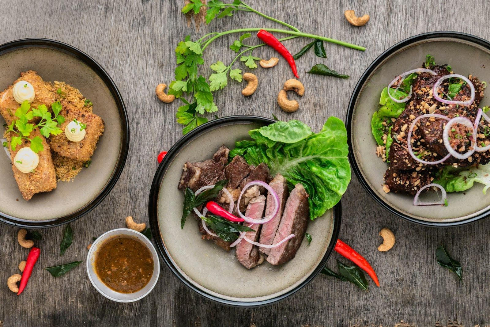Platos con carne, ensalada y vegetales